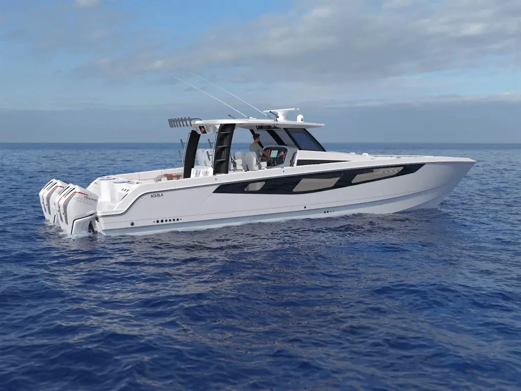 A sleek white motorboat with three outboard engines, cruising on calm blue waters under a partly cloudy sky.